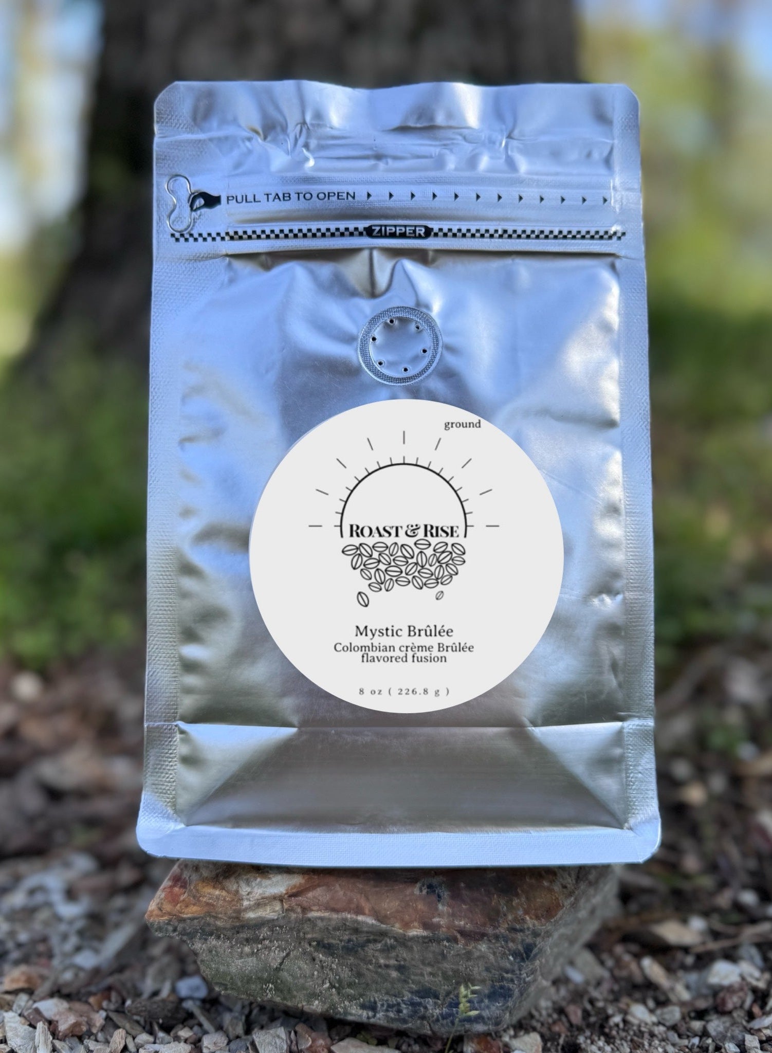 A sealed, transparent plastic package of Mystic Brulee coffee beans with a white label showing the product name and brand.